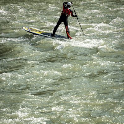 VERONA, ITALY - SEPT 19, 2020: a man on his Stand up Paddleboarding (SUP), paddles in the rapids of the Adige river in Verona downtown. Veneto, Italy, Europe